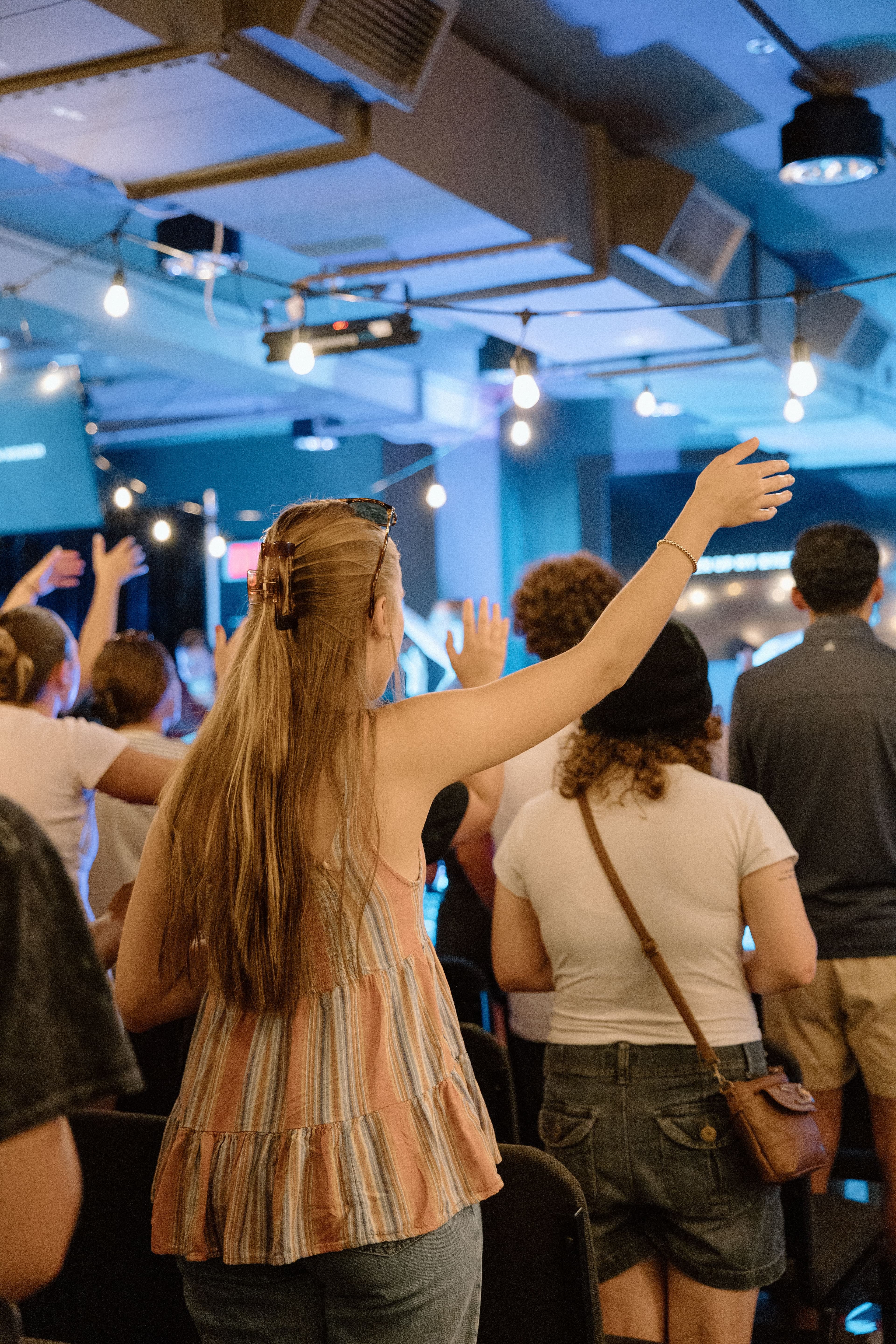 1 student with hand raised in worship