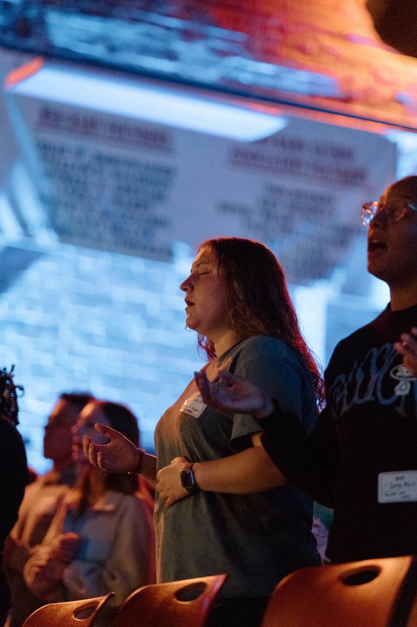 Students worshipping together with hands raised